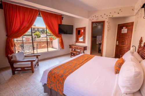 a bedroom with a large bed and a window at Hotel Agua Escondida in Taxco de Alarcón