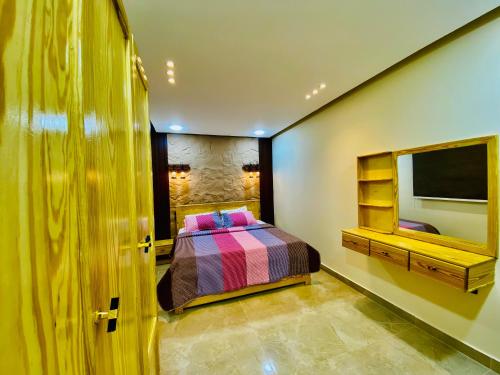 a bedroom with a bed and a tv on a wall at Emerald flat in Marsa Alam City