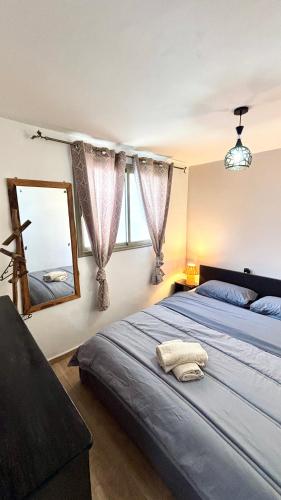 a bedroom with two beds and a mirror at Surf house apartment in Oualidia
