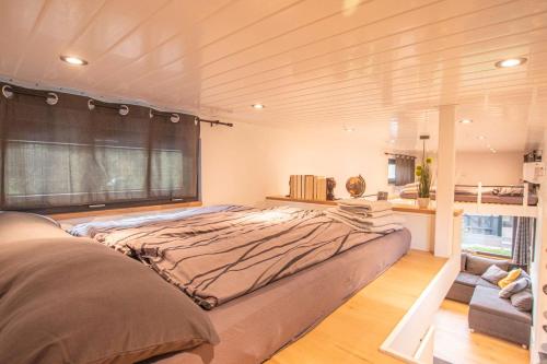 a large bed in a room with a window at Gemütliches Tiny House mit Terrasse & Klima an Badesee & Naturpanorama für max 4 Gäste in Salzhemmendorf