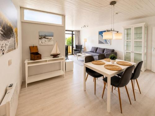 a dining room and living room with a table and chairs at Strandläufer in Wendtorf