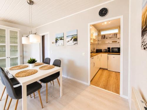 a dining room and kitchen with a table and chairs at Strandläufer in Wendtorf