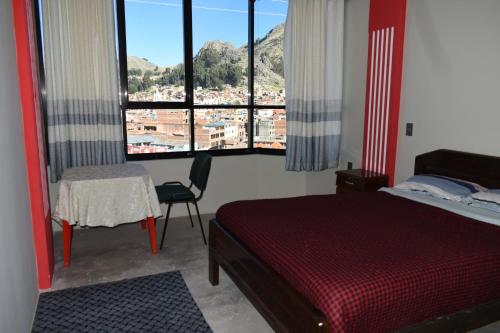a bedroom with a bed and a table and windows at Nexus Hotel & Coworking in Copacabana