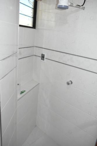 a white bathroom with a shower with a toilet at Nexus Hotel & Coworking in Copacabana