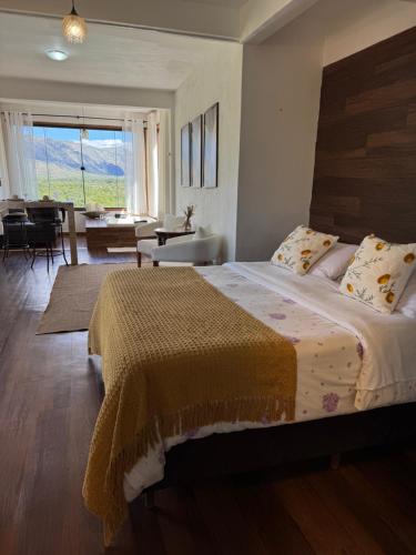 a bedroom with a large bed and a living room at Pousada Belvedere da Serra in Serra do Cipo