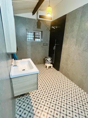 a bathroom with a sink and a tiled floor at Springdale Villa in Kodaikānāl