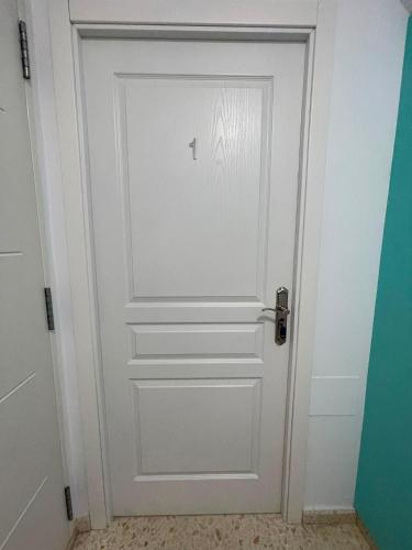 a white door with a silver handle in a room at Sanpau in Vejer de la Frontera