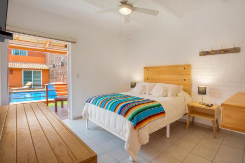 a bedroom with a bed and a balcony with a pool at Riberas Suites in Chapala