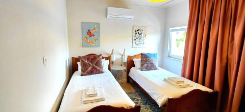 a bedroom with two beds and a window at Retreat Villa, Hot tub, BBQ in Lisbon