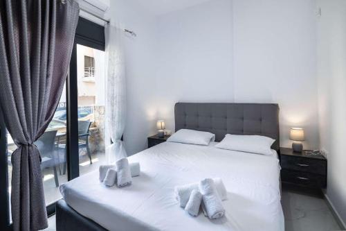 a bedroom with a white bed with towels on it at Aurelio Luxury Apartments in Paloúkia