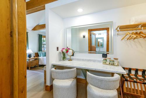 a bathroom with a vanity with two stools and a mirror at Harvest and Hearth in Galena