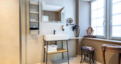 a bathroom with a sink and a mirror at Hotel Restaurant L'Orchidee in Ensisheim