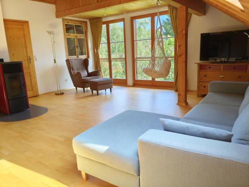 a living room with a couch and a tv at Chalet-Loft im Schwarzwaldhof Wutachblick in Bonndorf im Schwarzwald