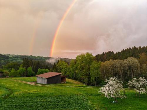 a rainbow over a field with a barn at Chalet-Loft im Schwarzwaldhof Wutachblick in Bonndorf im Schwarzwald