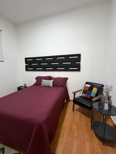 a bedroom with a purple bed and a chair at casa granada en Carranza in San Luis Potosí