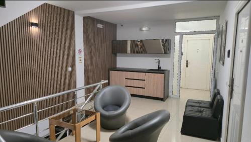 a living room with a grey chair and a sink at Apartments Philip II in Ohrid