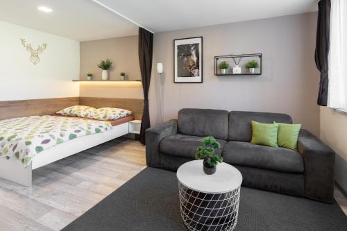 a living room with a couch and a bed at Apartmány Stožec - Nella Premium in Stožec
