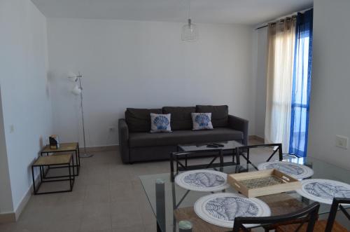 a living room with a couch and tables at Montaña Tirba in Costa Calma
