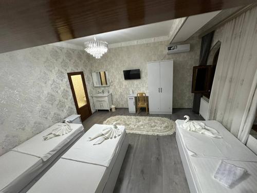a living room with two beds and a television at LAYALI boutique TERRACE & Café in Bukhara