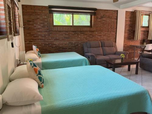 a room with two beds and a living room at Brisa Suave Studio Suite in Punta Mita