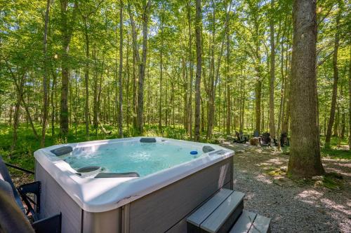 a hot tub in the middle of a forest at Peace at Last by Railey Vacations in McHenry