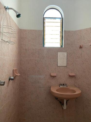 a bathroom with a sink and a window at Habitación 11 Posada Itzel in Oaxaca City
