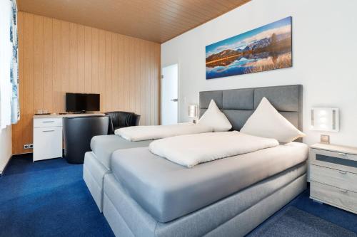 a hotel room with two beds and a television at Hotel Romäus in Villingen-Schwenningen