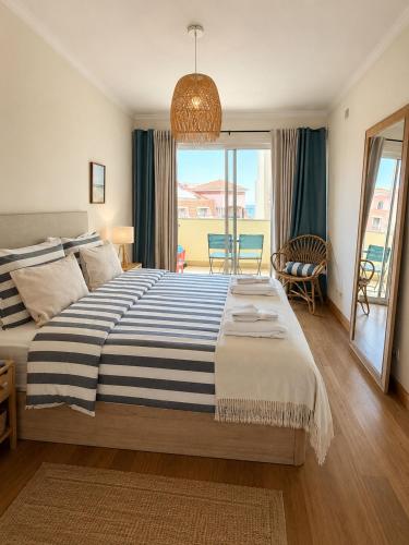 a bedroom with a large bed and a balcony at Atlantic Ocean View Apartment in Funchal