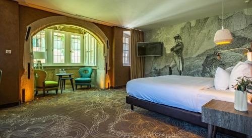 a hotel room with a bed and a tv at Hotel Restaurant L'Orchidee in Ensisheim