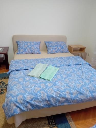 a bed with two sheets and two books on it at Smestaj Prokuplje in Prokuplje