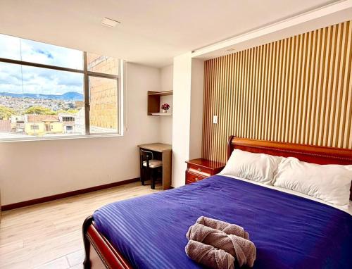 a bedroom with a bed and a large window at Departamento CENTRICO CENTRO LOJA in Loja