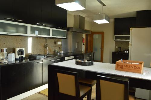 a kitchen with black cabinets and a white counter top at Cantinho do Minho - Ponte de Lima in Ponte de Lima