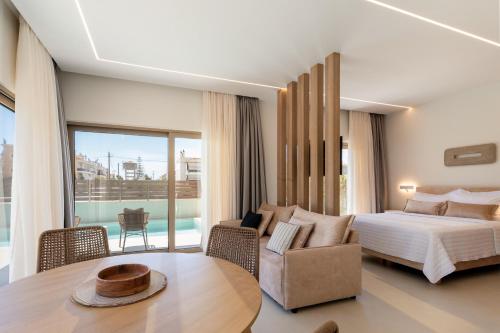 a bedroom with a bed and a couch and a table at IONE Suites in Preveza