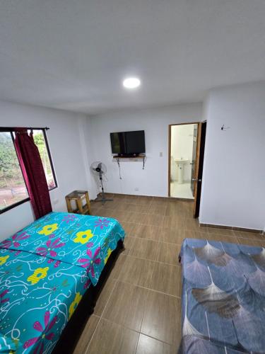 a bedroom with a bed and a flat screen tv at Finca hotel los cocos in Montenegro