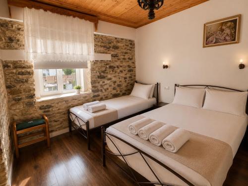 ein Schlafzimmer mit zwei Betten und einem Fenster in der Unterkunft Vila Drasa Guesthouse in Gjirokastër