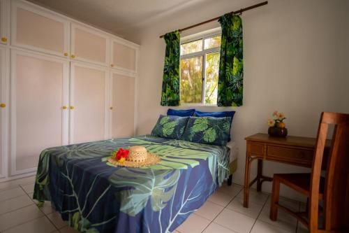 a bedroom with a bed with a hat on it at Bungalow Tearo in Tiripoa