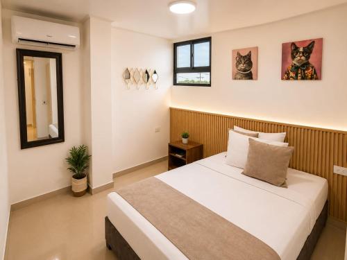 a bedroom with a bed and two cats on the wall at Hotel Gama Cartagena in Cartagena de Indias