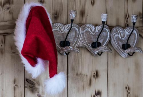 a red and white santa hat hanging on a wall at Le p'tit coin de chez nous in Dambach-la-Ville