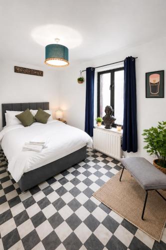 a bedroom with a bed and a checkered floor at Cosy Coach House - Belfast in Belfast