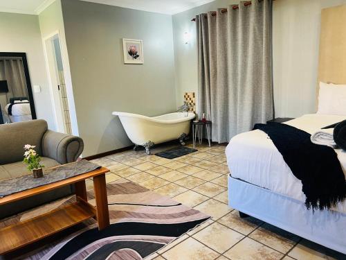 a bedroom with a bed and a tub in a room at De'Lush Oasis in Pretoria