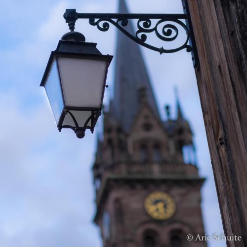 a street light in front of a clock tower at Le p'tit coin de chez nous in Dambach-la-Ville