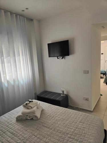 a bedroom with a bed and a flat screen tv at AnnAmuri appartamento 23 in Belpasso