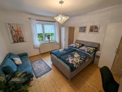 a bedroom with a bed and a couch and a window at Ferienwohnung Mutter in Twiste