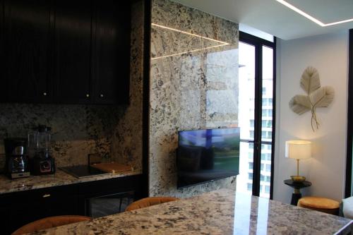 a kitchen with a counter with a tv and a table at Panoramic Lake View Cabo Norte Mérida in Mérida