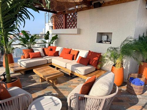 an outdoor patio with couches and tables and plants at NH Royal Urban Cartagena in Cartagena de Indias