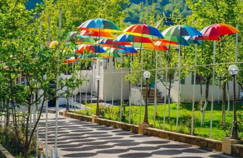 a row of colorful umbrellas on a sidewalk at WhiteHotelGabala in Gabala