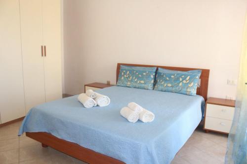 a bedroom with a bed with two towels on it at Casa Elena Floris in Teulada