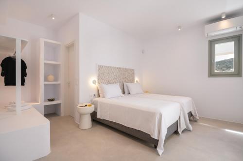 a white bedroom with a bed and a toilet at Villa Serenity Complex in Kampos Paros