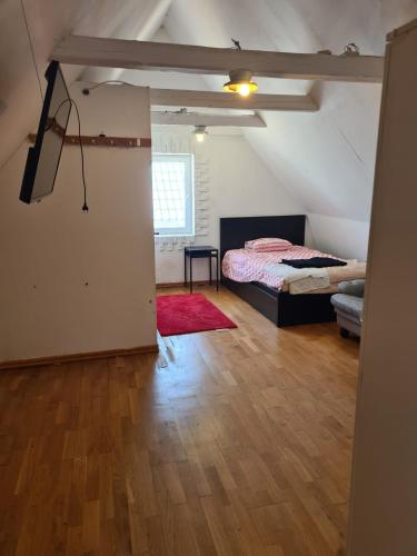 a bedroom with a bed and a room with a wooden floor at Blu hus in Norra Kverrestad