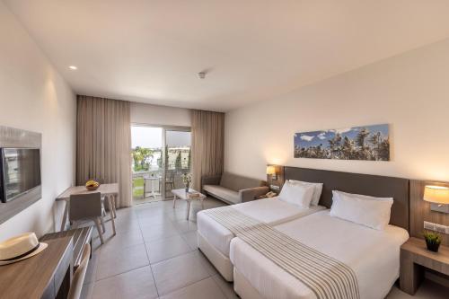 a hotel room with a large bed and a desk at Euronapa Hotel in Ayia Napa